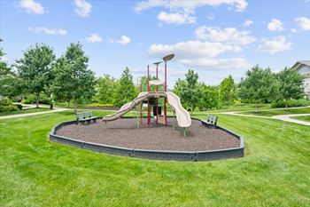 A playground with a slide and a red pole.