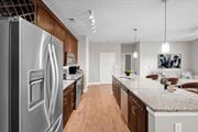 Lenexa townhouse for rent - a kitchen with stainless steel appliances and granite counter tops at Prairie Creek Apartments & Townhomes Apartments, Kansas