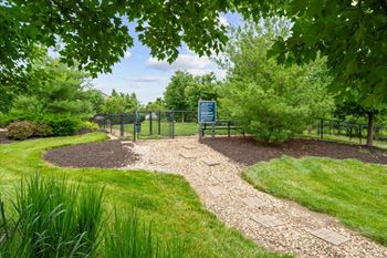 A sign is in a fenced area with a gravel path leading to it.