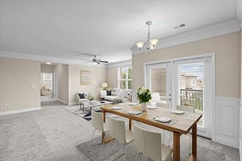 A dining room and living room with a table and chairs