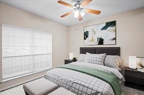 Dallas apartment for rent - a bedroom with a large window and a ceiling fan at Creekview Apartment Homes, Dallas, TX