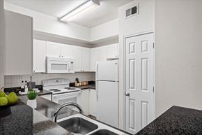 Frisco apartment for rent - a kitchen with white cabinets and white appliances at Wade Crossing Apartment Homes, Frisco, Texas