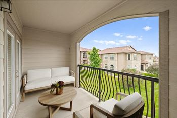 A patio with a couch and a table on a balcony