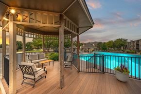 Lenexa apartment for rent - a poolside deck with chairs and a gazebo overlooking a swimming pool