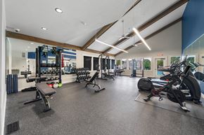 Lenexa apartment for rent - a gym with weights and cardio equipment on the floor and glass walls