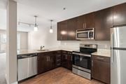 Kansas City apartment for rent - a kitchen with dark wood cabinets and stainless steel appliances at Cambria Luxury Apartment Homes, Missouri