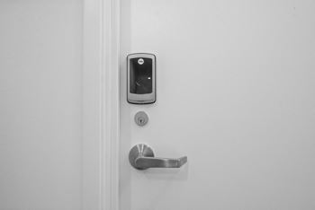 An iphone on a white door with a door handle