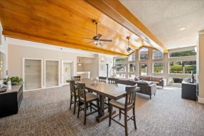 Olathe apartment for rent - Open clubhouse area with dining seating, natural light, and views of outdoor amenities.