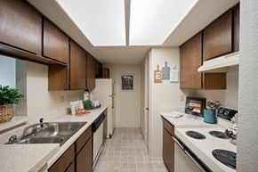 Overland Park apartment for rent - A kitchen with brown cabinets and a white counter.