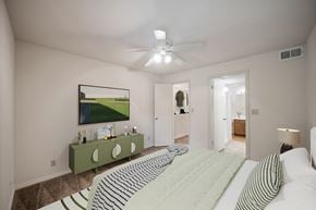 Overland Park apartment for rent - A bedroom with a large bed and a painting on the wall.