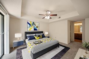 Overland Park apartment for rent - A bedroom with a large bed and a ceiling fan.