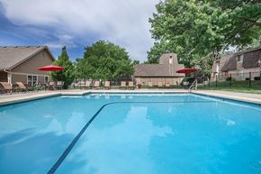 Overland Park apartment for rent - A clean outdoor swimming pool with trees and lounge seating at Preston Court Apartment Homes, Overland Park, KS