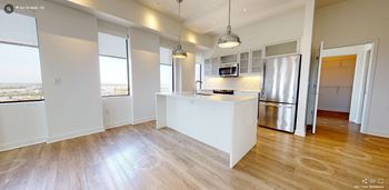 A kitchen with white walls and a wooden floor