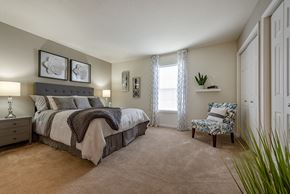 Rock Hill apartment for rent - A bedroom with a bed, chair, and two framed pictures on the wall.