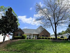 Rock Hill apartment for rent - A house with a green lawn and trees in front.