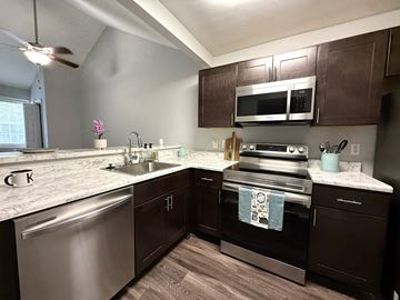 Rock Hill apartment for rent - A kitchen with dark brown cabinets and stainless steel appliances.