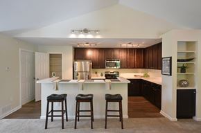 Raleigh apartment for rent - A kitchen with a white island and bar stools.
