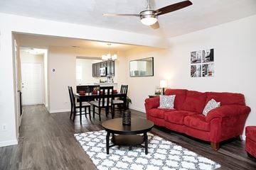 Raleigh townhouse for rent - A living room with a red couch and a dining table.