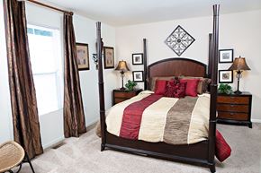 Arden apartment for rent - A bedroom with a canopy bed and a chair.