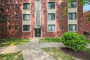 Hyattsville apartment for rent - exterior view of a brick apartment building with sidewalks and grass