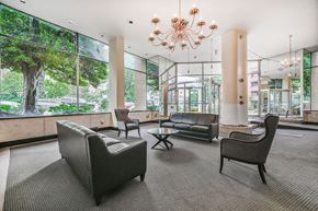 Washington apartment for rent - A large room with a chandelier and a view of trees outside the windows.
