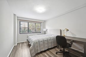 Washington apartment for rent - a bedroom with a bed and a desk and a window