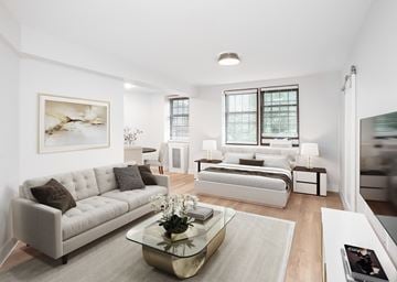 Washington apartment for rent - A modern living room with a white couch and a coffee table in the center.