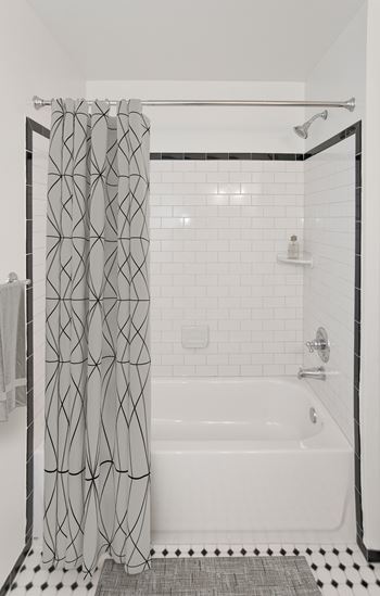 Bathrooms with black and white ceramic tile, marble countertops, and shaker cabinets