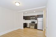 Washington apartment for rent - A kitchen with a white fridge and stove top oven.