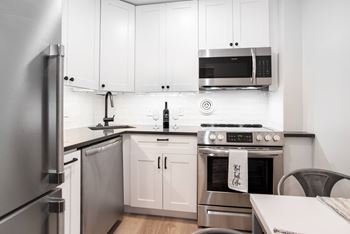 Custom white shaker cabinetry and matte black hardware