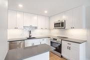 Washington apartment for rent - A modern kitchen with white cabinets and stainless steel appliances.