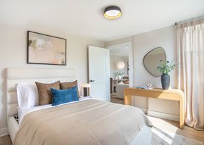 Washington apartment for rent - A bedroom with a large bed and a mirror on the wall.