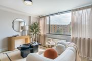 Washington apartment for rent - A living room with a large window and a view of a building outside.