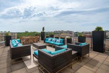 Washington apartment for rent - A patio with a table and chairs overlooking a cityscape.