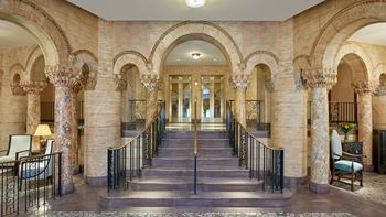 Grand reception lobby with statuary fountain, scagliola columns, and dramatic skylight