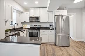Hyattsville apartment for rent - a kitchen with white cabinets and stainless steel appliances