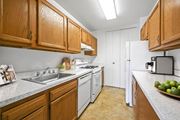 Washington apartment for rent - A kitchen with wooden cabinets and a white refrigerator.