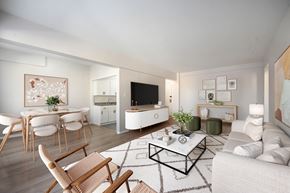 Washington apartment for rent - A modern living room with a white sofa, wooden chairs, and a coffee table.