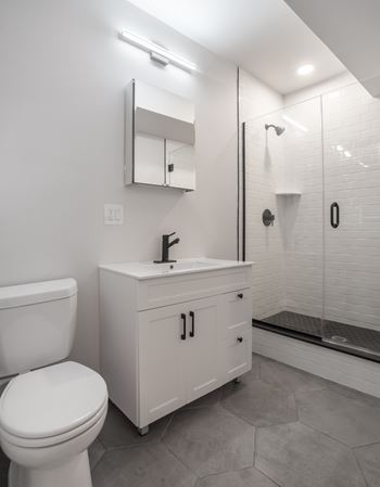 Bathrooms with ceramic tile, operable windows, and vanity storage cabinet