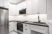Washington apartment for rent - A modern kitchen with white cabinets and stainless steel appliances.