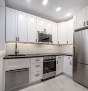 Washington apartment for rent - A modern kitchen with white cabinets and stainless steel appliances.