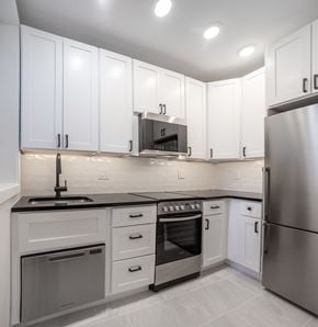 Washington apartment for rent - A modern kitchen with white cabinets and stainless steel appliances.