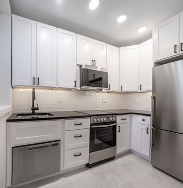 Washington apartment for rent - A modern kitchen with white cabinets and stainless steel appliances.