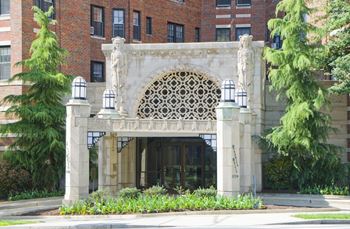 Elegant porte cochere covered entry with carved limestone reliefs and original art deco lighting fixtures,