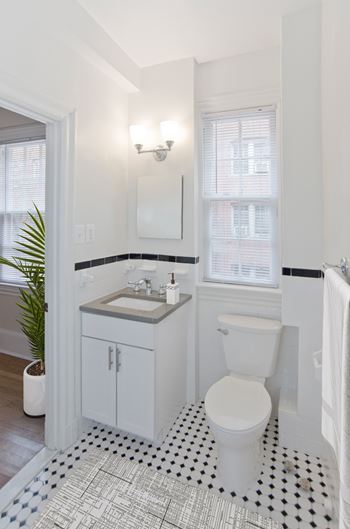 Bathrooms with black and white ceramic tile, marble countertops, and shaker cabinets