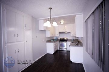 Inglewood apartment for rent - a kitchen with white cabinets and a dark wood floor