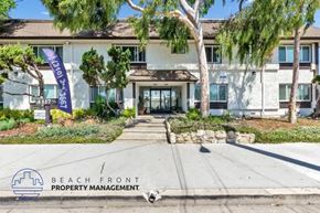 Hawthorne apartment for rent - a beach front property management building with a dog in front of it
