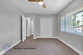Hawthorne apartment for rent - an empty living room with a white door and a window
