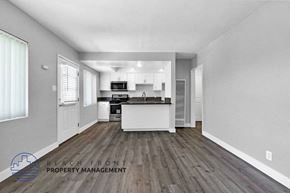 Hawthorne apartment for rent - an open kitchen and living room with white walls and wood floors