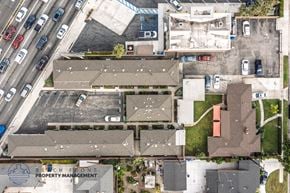 Downey apartment for rent - An aerial view of a parking lot with a building and a sign that says "Beachfront Property Management".